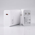 A white 67W USB-C power adapter shown from both the front and back angles on a clean, light gray reflective surface.