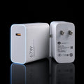 A 67W white USB-C power adapter shown from two angles: the front face with a USB-C port and the back face with two US plug pins and printed specifications, set against a black background with a reflective surface.