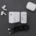 A flat-lay product shot of a white 67W wireless charging setup on a dark gray textured background, including a white wireless earbud charging case, two white wireless earbuds, a white wall charger, a black USB-C to USB-C cable, and a white earbud charging case.